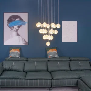 Warm-lit crystal ball pendant chandelier in contemporary living room with dark blue walls and green leather sofa