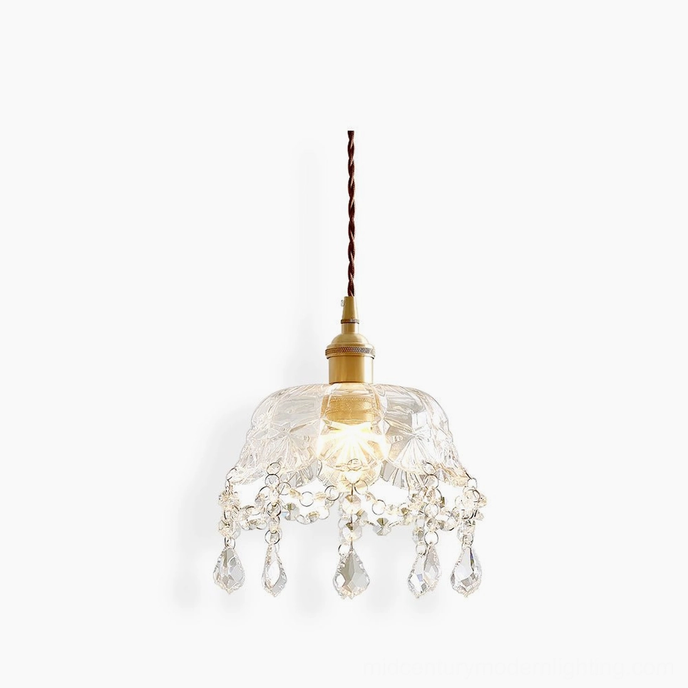 Crystal glass jewel pendant light with pressed floral pattern, gold brass fixture, studio front view