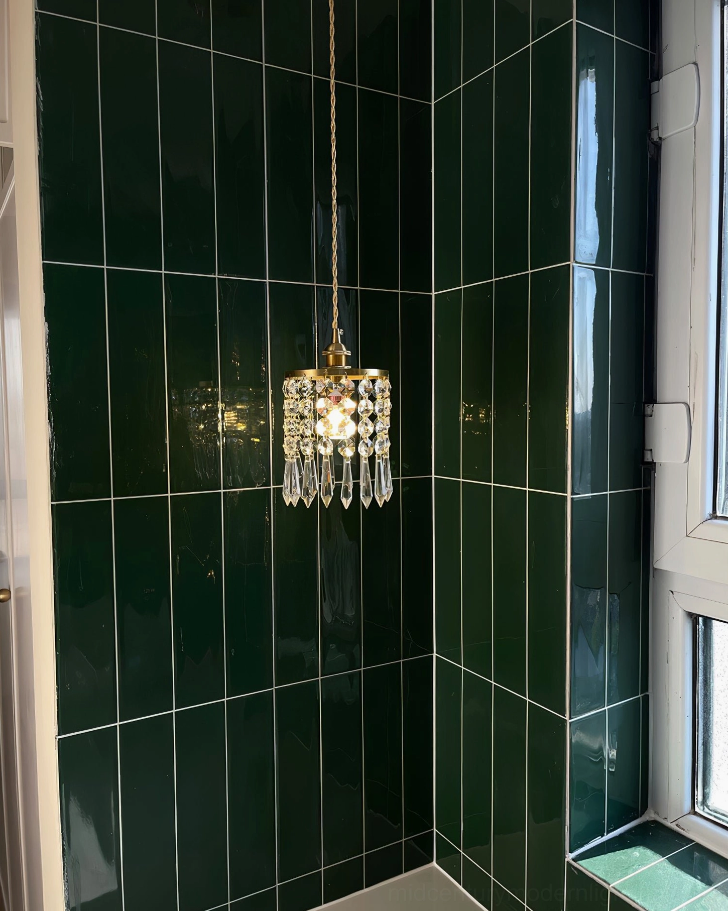 Clear crystal pendant fixture with brass ceiling mount, installation detail