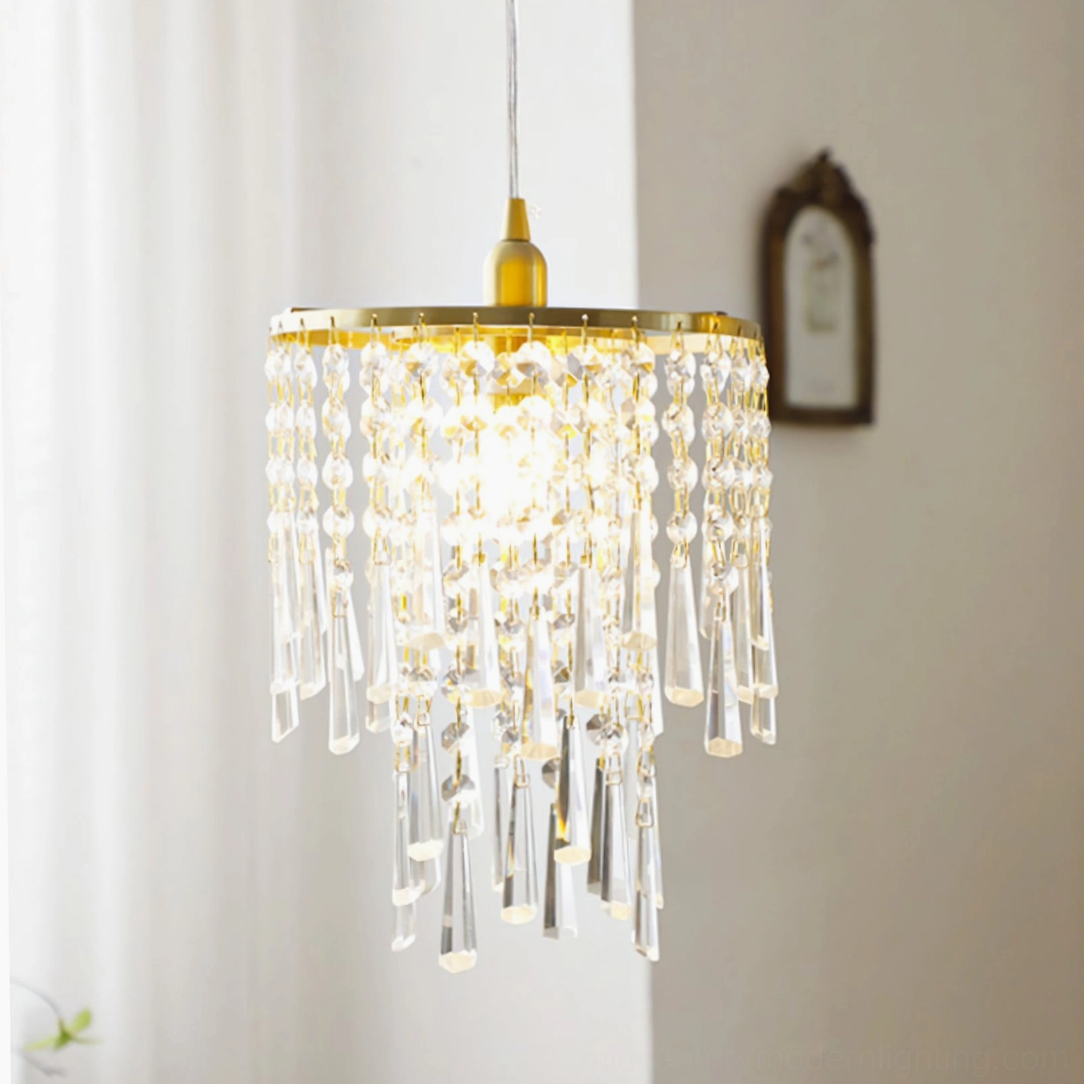 Crystal pendant chandelier mounted to ornate ceiling plate with cascading crystal strands, low-angle front view