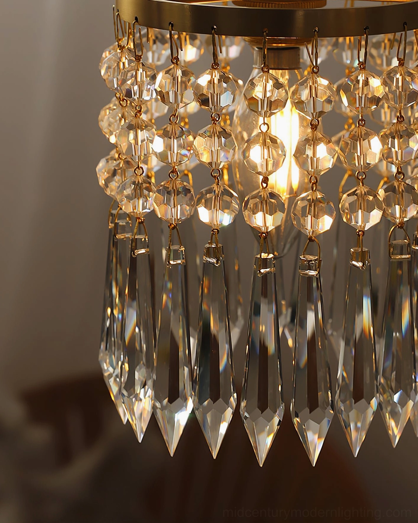 Close-up crystal pendant light showing faceted beads and internal bulb glow