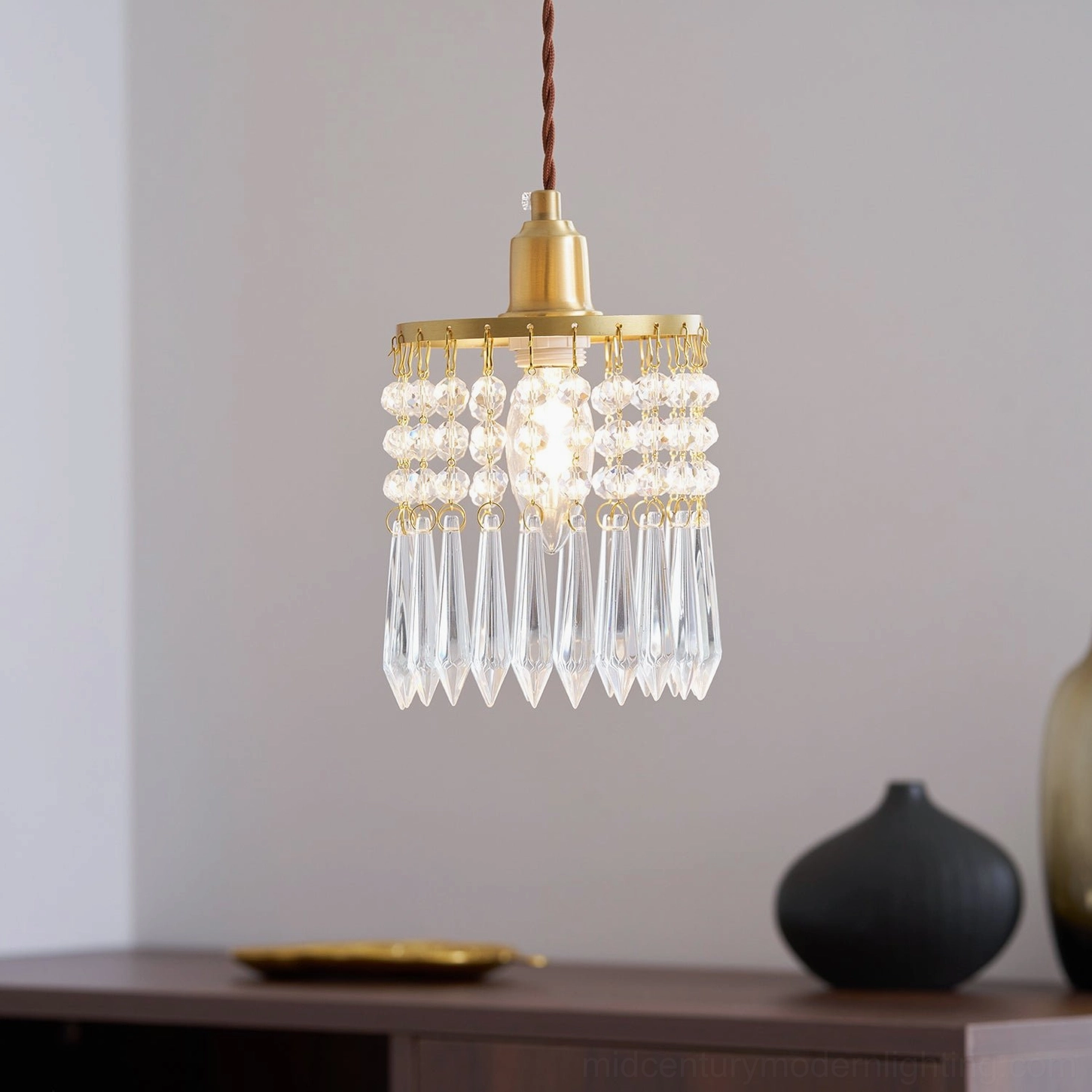 Clear crystal pendant with gold-finished brass components, architectural detail