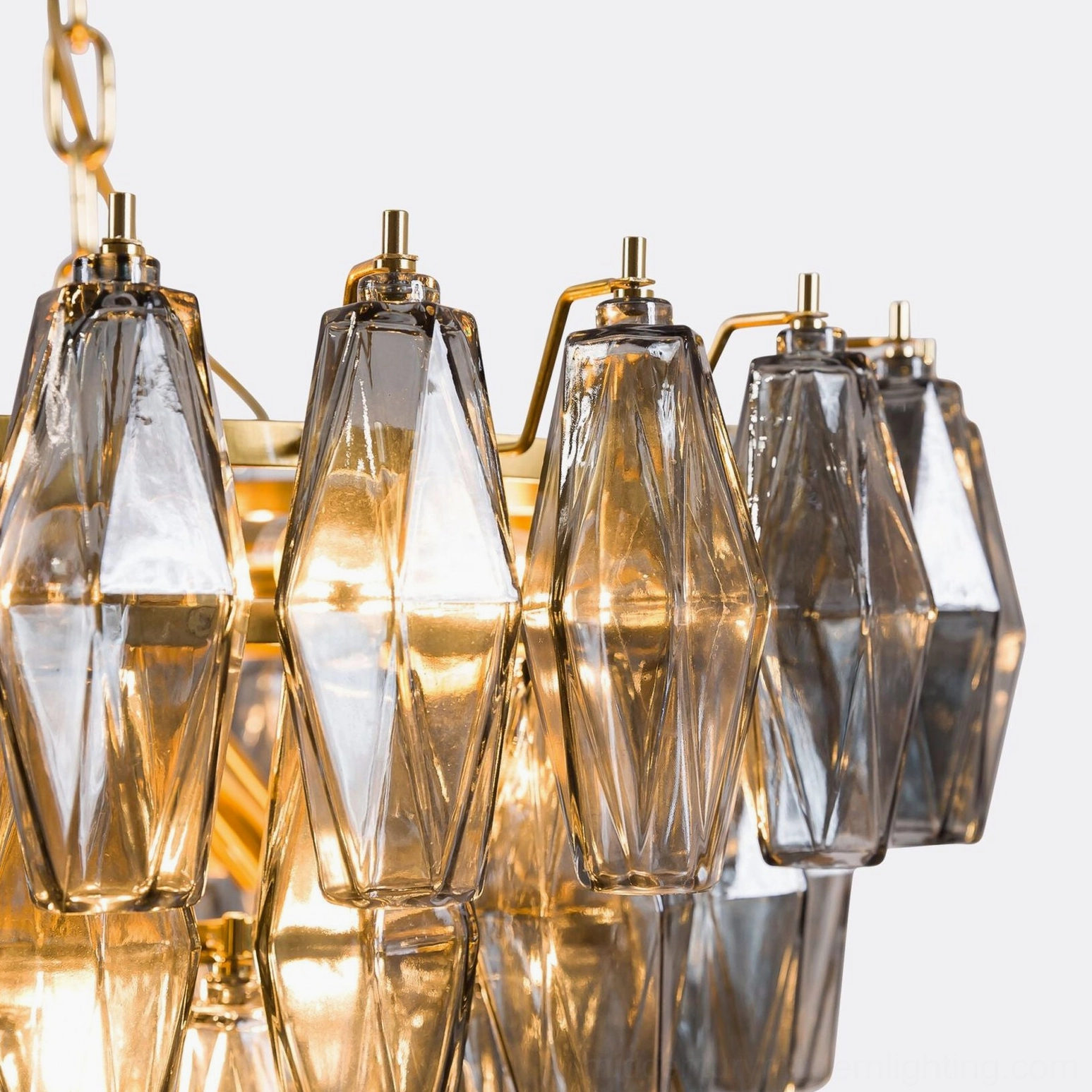 Close-up detailed view of faceted crystal prism components and brass mounting hardware