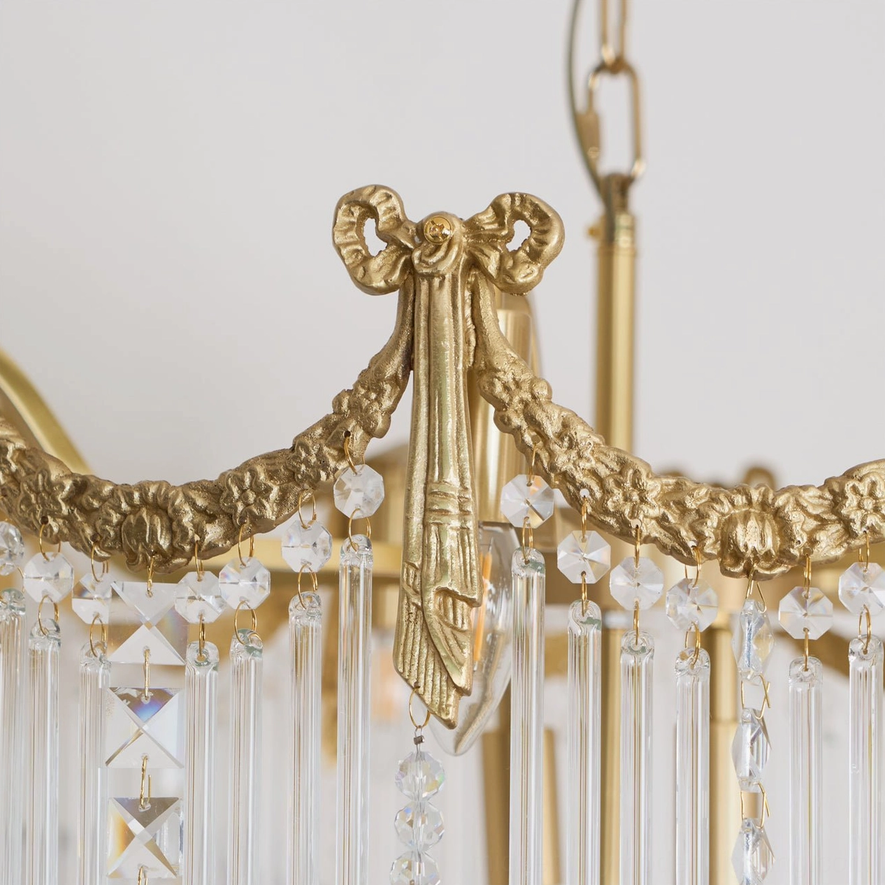 Crystal teardrop chandelier with brass metal structure and cascading glass pendants in contemporary interior setting