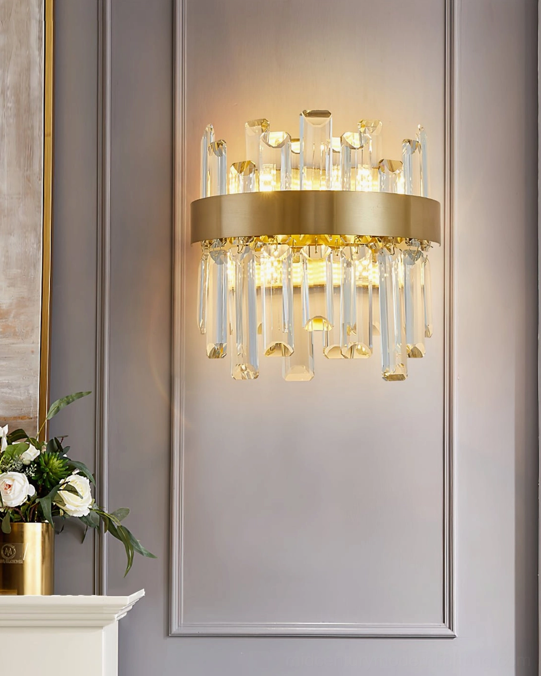 Brass crystal sconce in paneled living room wall, complementing luxury home interior with floral table arrangement and sophisticated décor