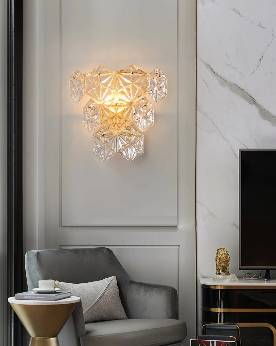 Modern gold brass and clear glass crystal wall sconce detail showing light refraction