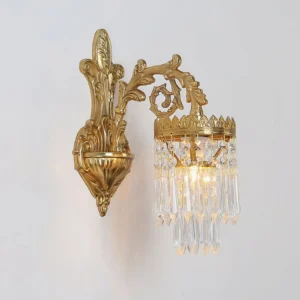 Side profile close-up of vintage crystal wall lamp showing intricate brass scrollwork and dangling crystal prisms