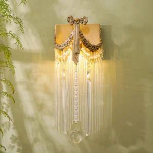 Vintage brass crystal wall lamp glowing with warm ambient light in botanical setting
