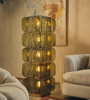 Olive green Cubo Totem floor lamp in warm modern living room, demonstrating moody gallery-style ambient lighting beside mid-century seating