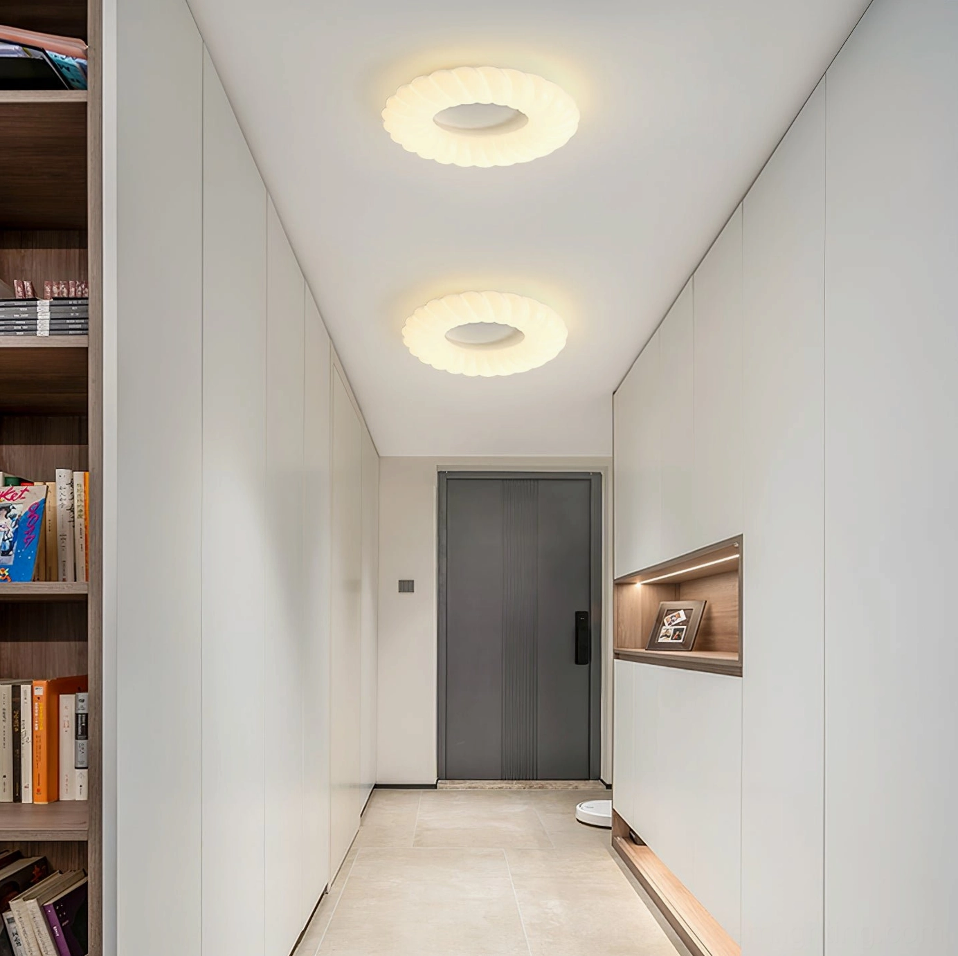 Dual Cumulus ceiling lamps in residential entryway with built-in bookshelf and soft warm lighting