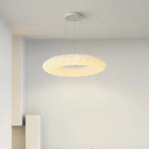 Modern donut pendant light installed in minimalist residential interior corner, side-angle view
