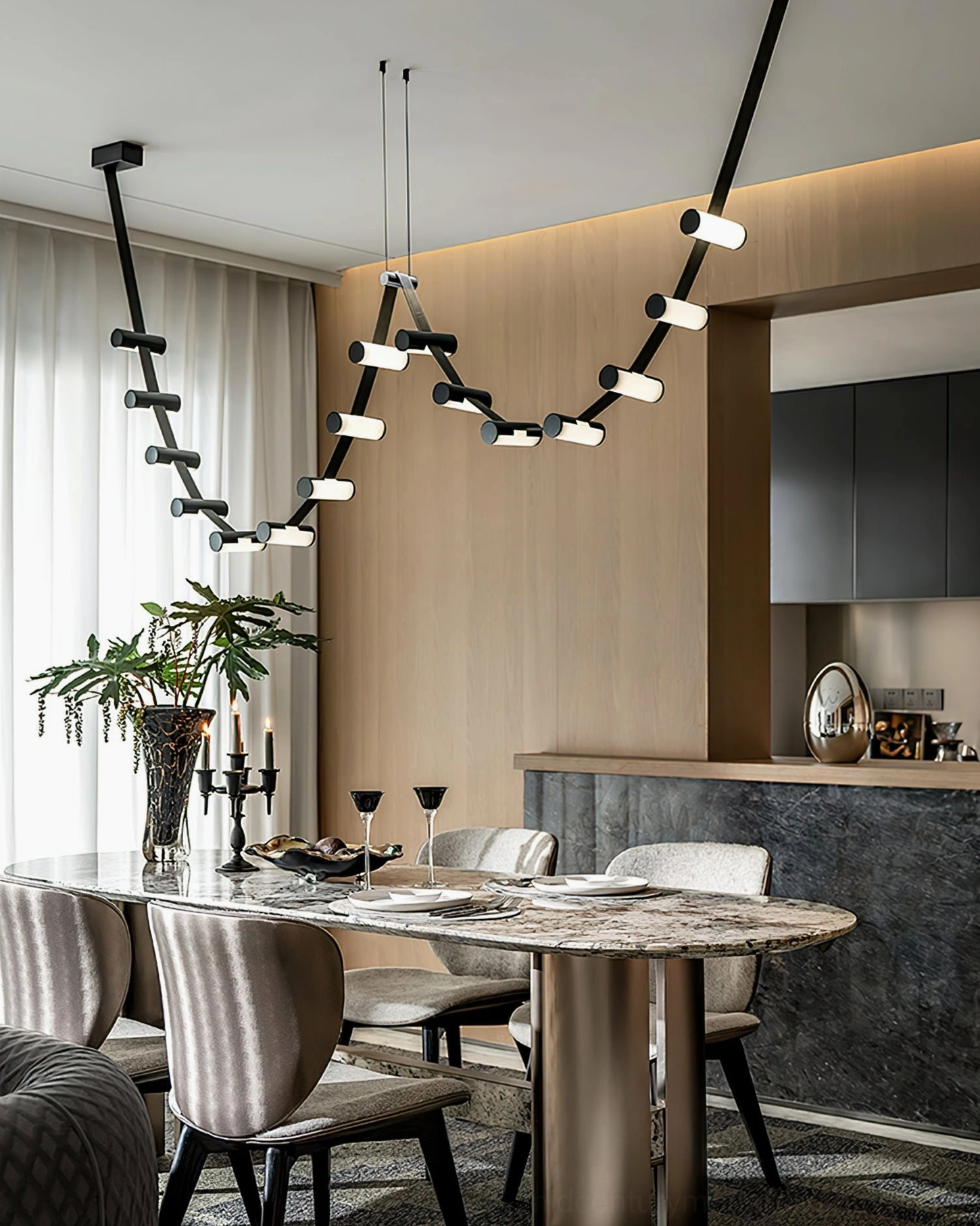 Contemporary curved pendant chandelier illuminating open-concept kitchen dining area, minimalist modern home decor
