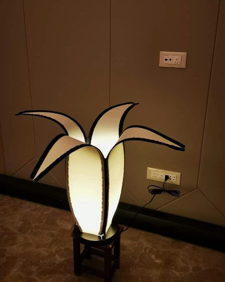 Curved banana table lamp silhouette against warm interior lighting and home furnishings