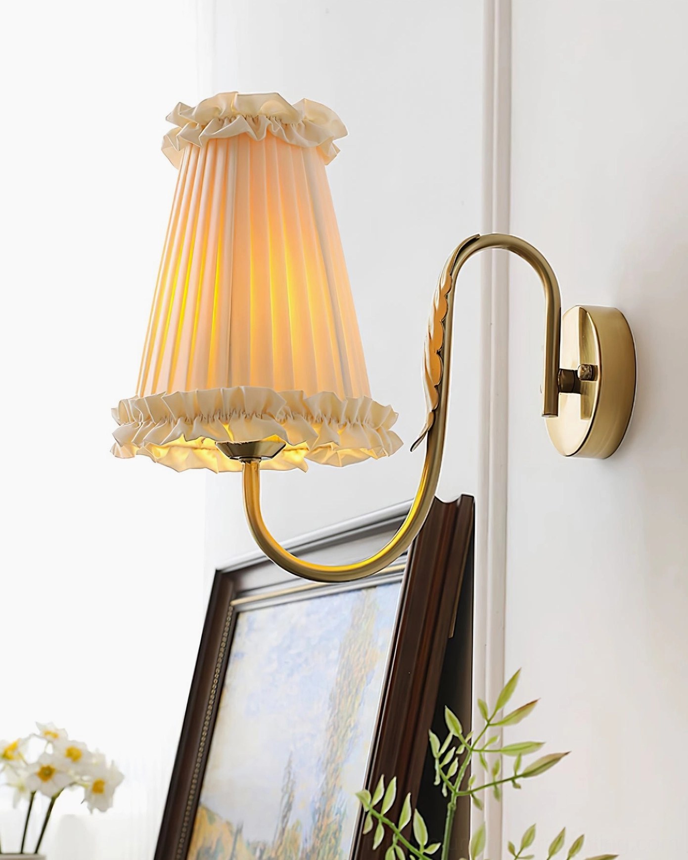 Right-facing view of wall-mounted lamp with curved metal arm glowing on white wall interior