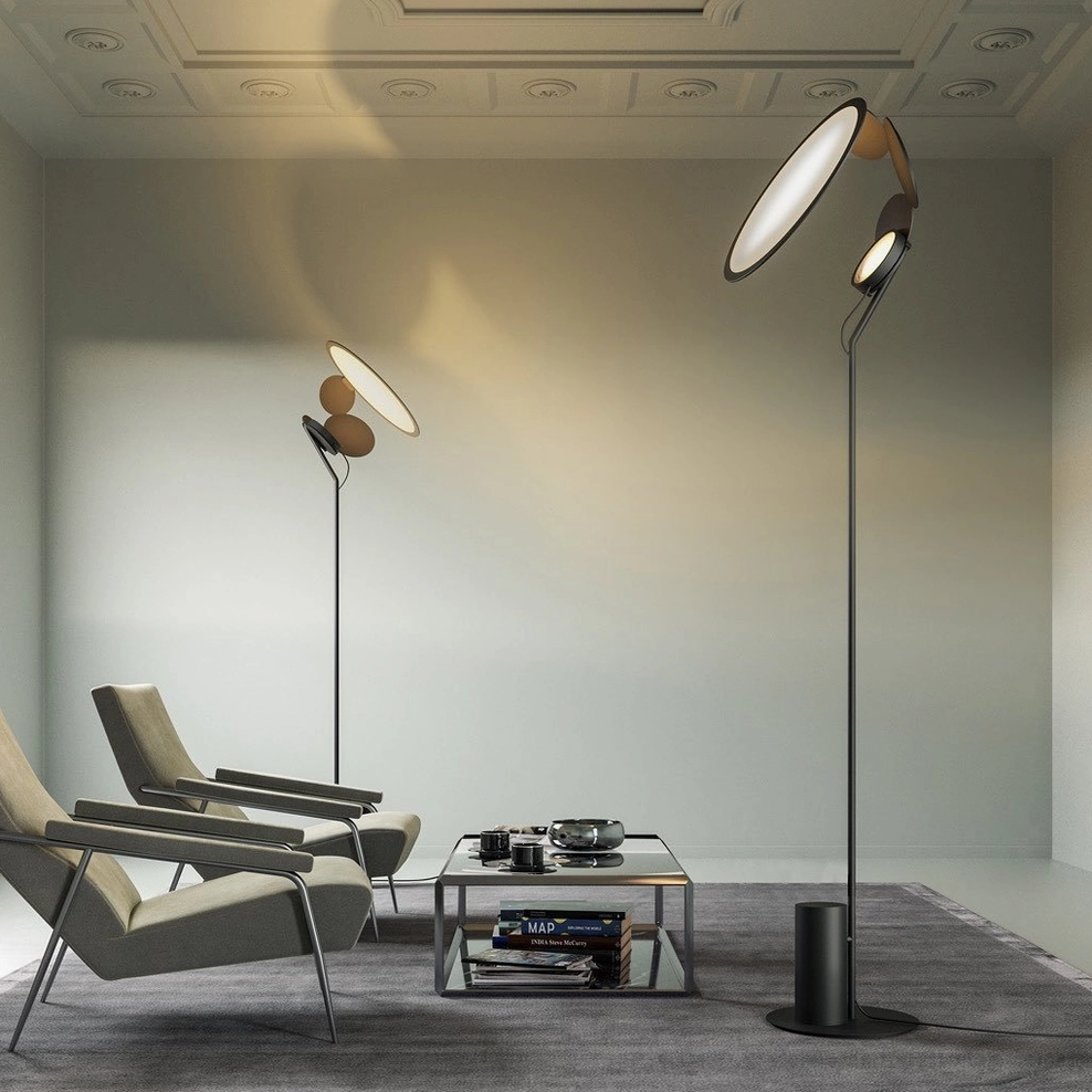 Wide room view of Cut modern table lamp with tall matte black pole and dual oval lamp heads in lounge setting