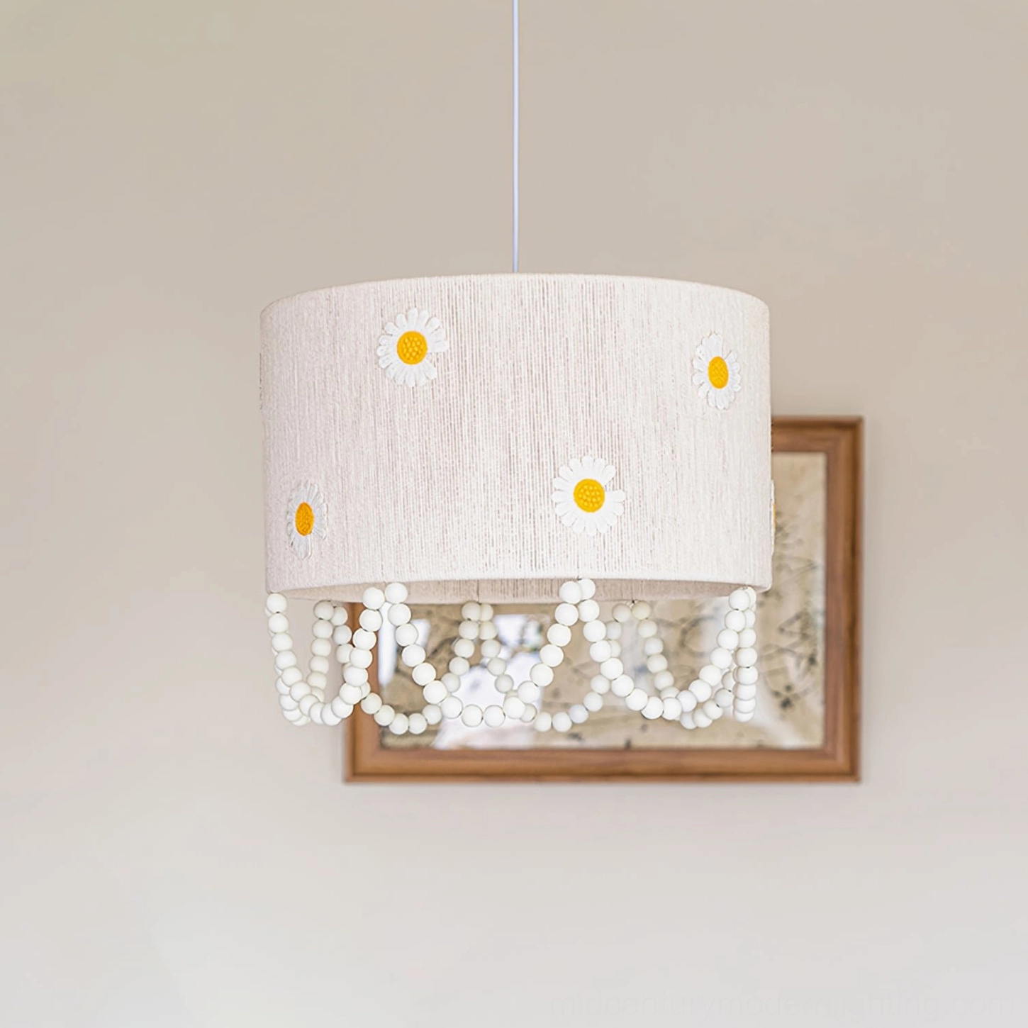 Close-up of daisy flower pendant lamp with woven texture yellow-center daisy motifs and draped pearl chain details indoor setting