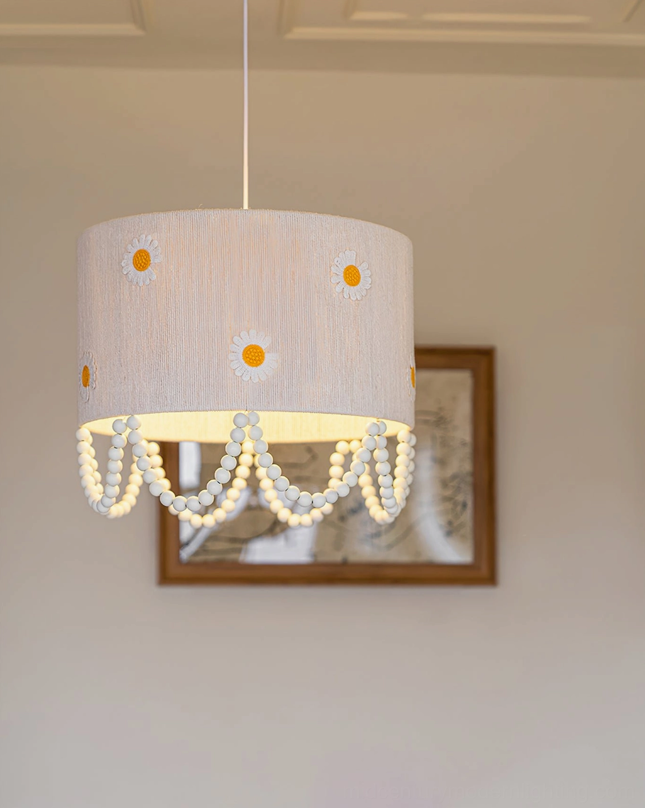 Illuminated daisy flower pendant lamp warm glow showing embroidered daisy details pearl trim lighting effect