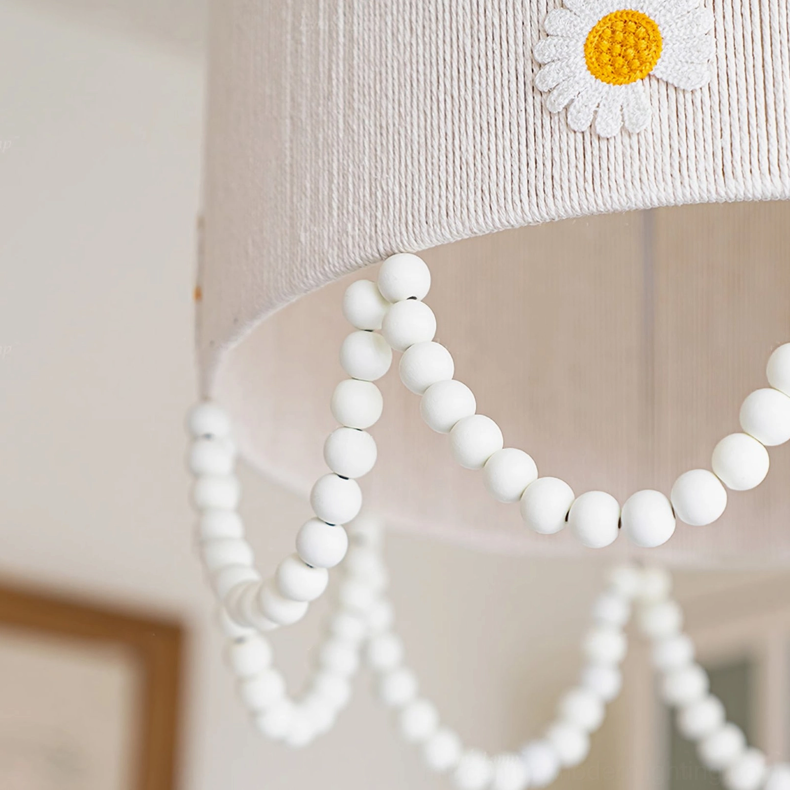 Low-angle close-up of daisy flower pendant lamp shade showing woven rope texture daisy appliques and pearl strands