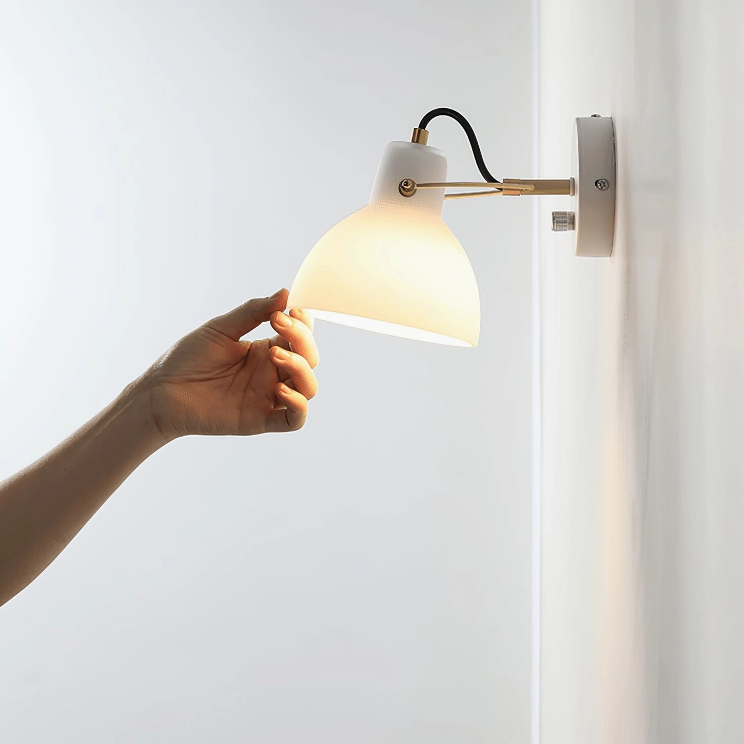 Side view of Daniel wall lamp with adjustable arm against indoor wall with sheer curtain, showing ambient lighting effect