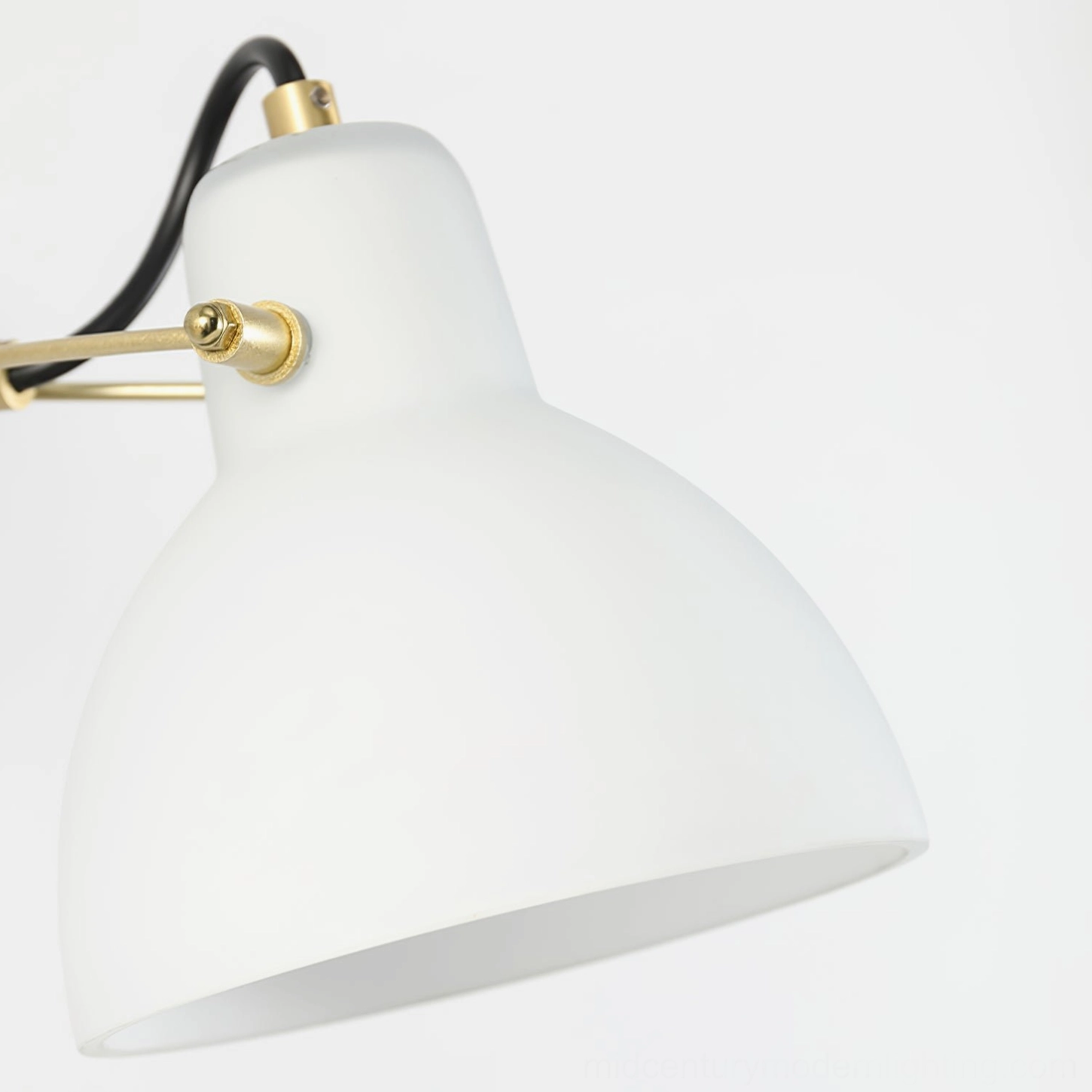 Modern wall sconce with frosted glass shade and brass articulated arm for directional task lighting