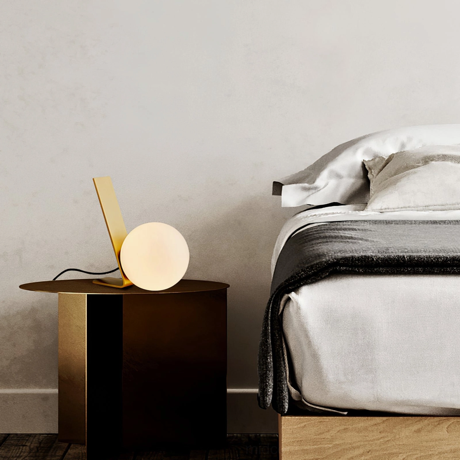 Daphne brass lamp on dark nightstand in modern bedroom setting with neutral bedding