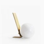 Daphne satin brass table lamp with frosted white glass shade, front view on minimalist background