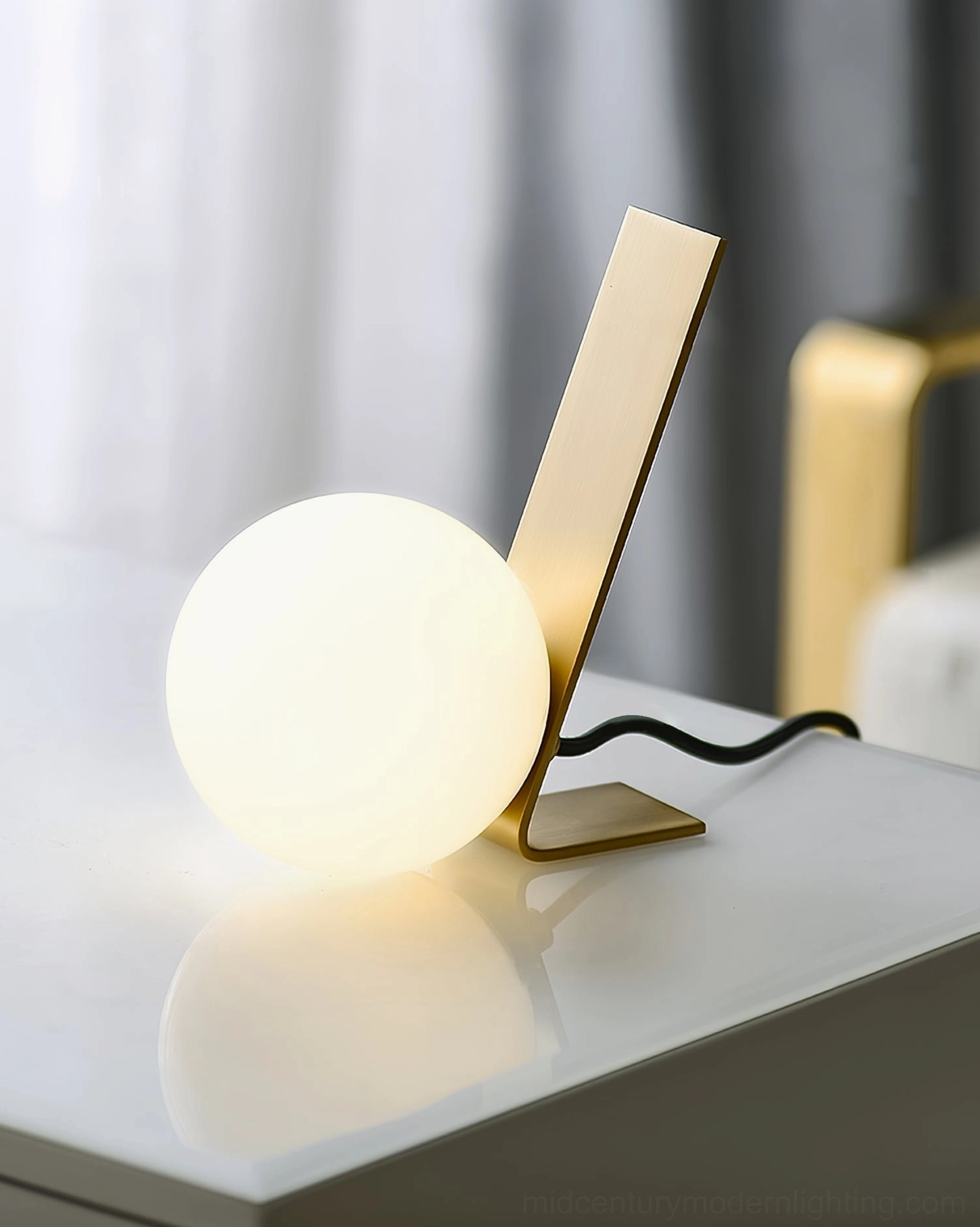 Daphne glowing table lamp with warm ambient lighting and visible power cord on bright surface