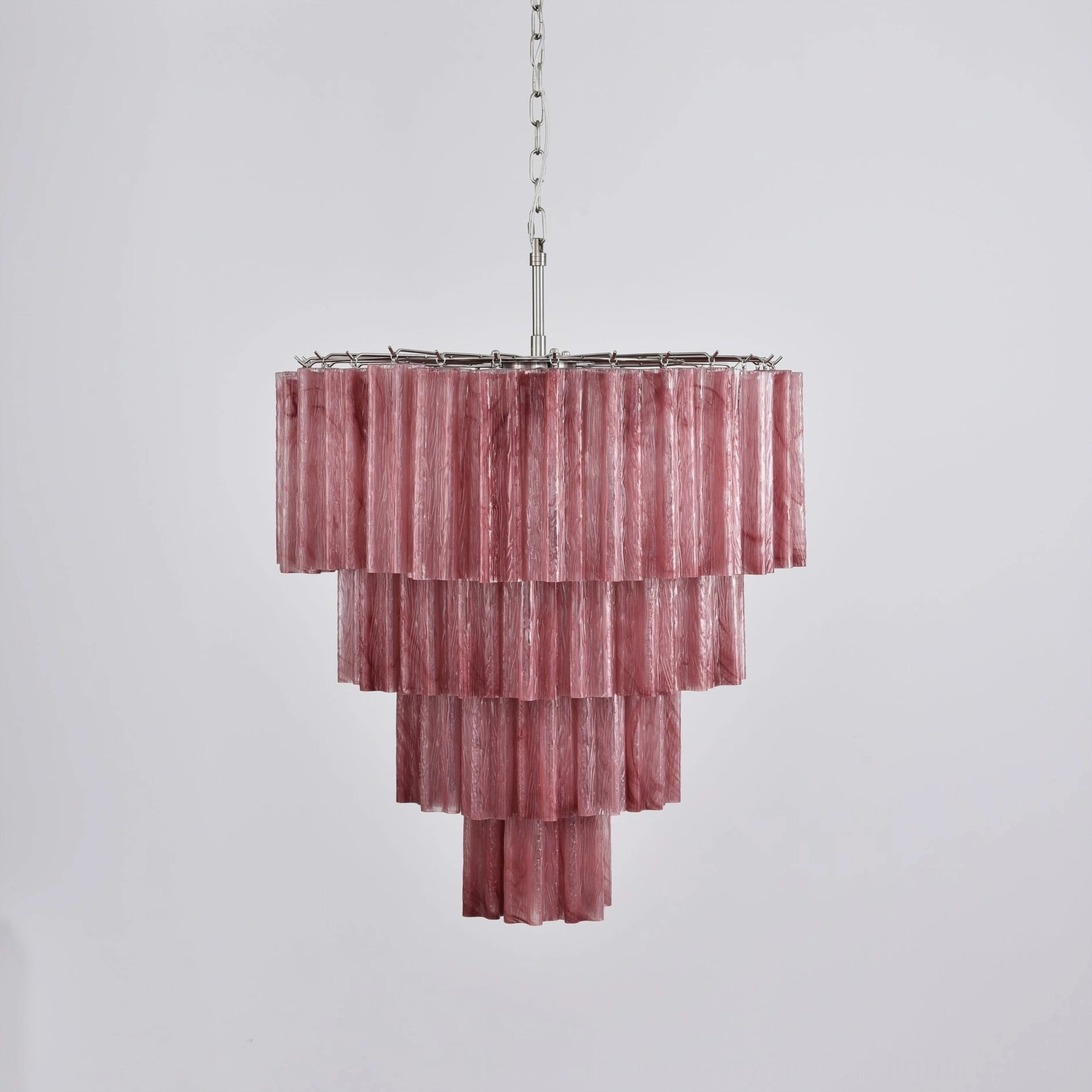 Dark pink tiered glass chandelier side view with brushed metal chain suspension detail