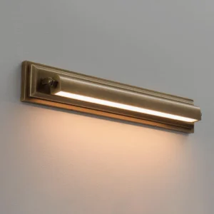 Illuminated Davenport wall sconce showing warm white LED light strip, layered brass frame and stepped architectural detail