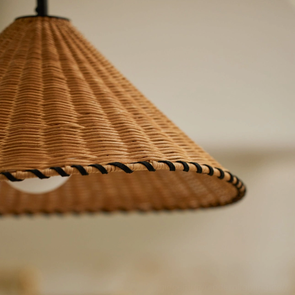 Natural rattan hand-woven pendant light suspended from slim black cord, frosted opal globe visible beneath shade