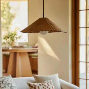 Davida rattan pendant light installed in warm living room, side angle view showing woven texture and ambient light diffusion