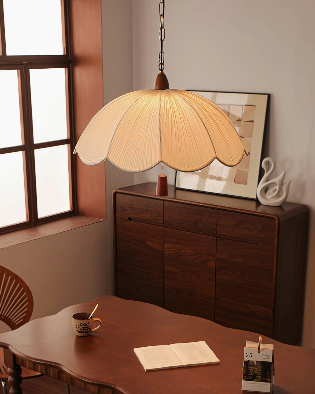 Mid-century scalloped pendant light in dining room with sideboard and natural window light