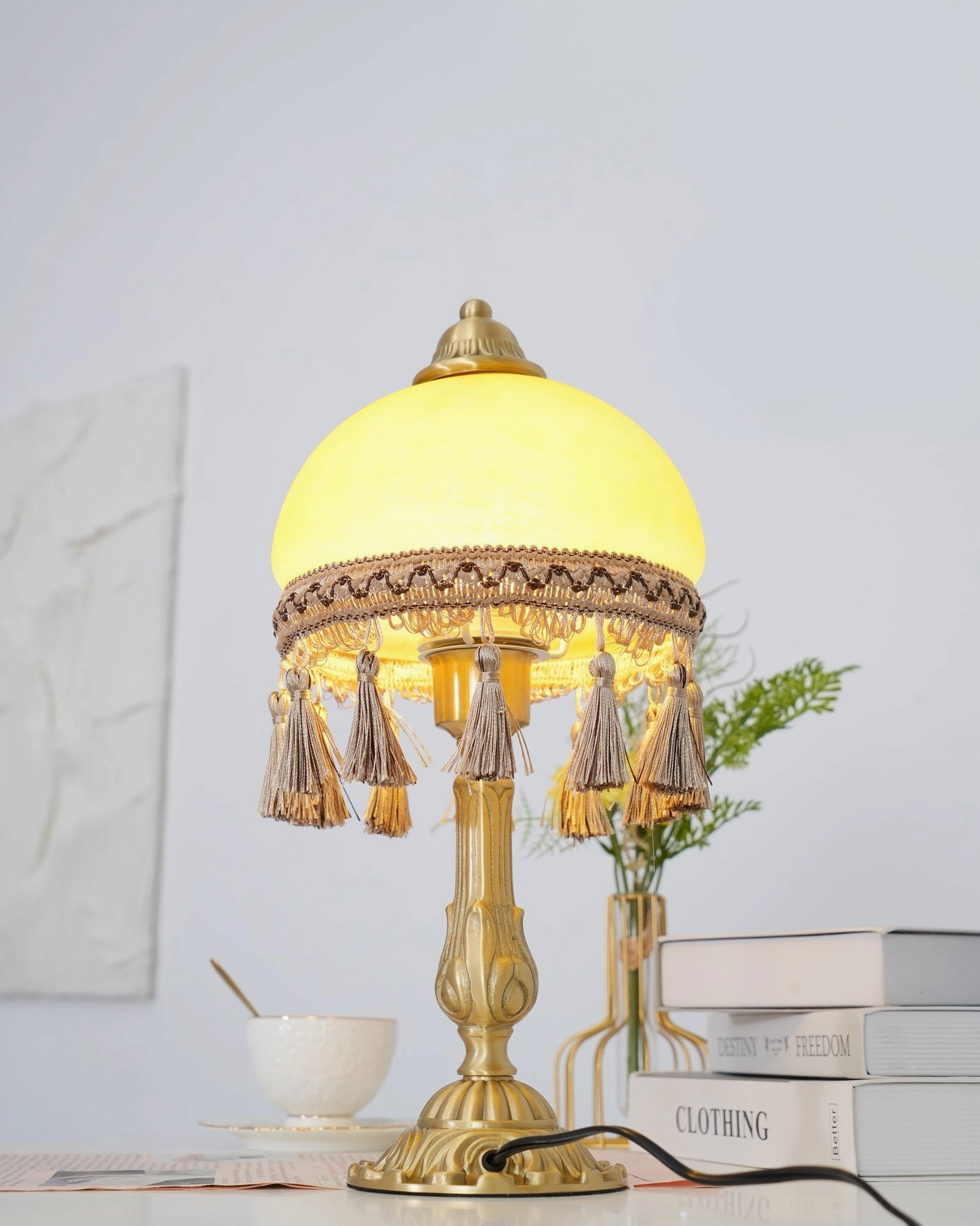 Decorative brass tassel lamp base and glass dome assembly close-up view