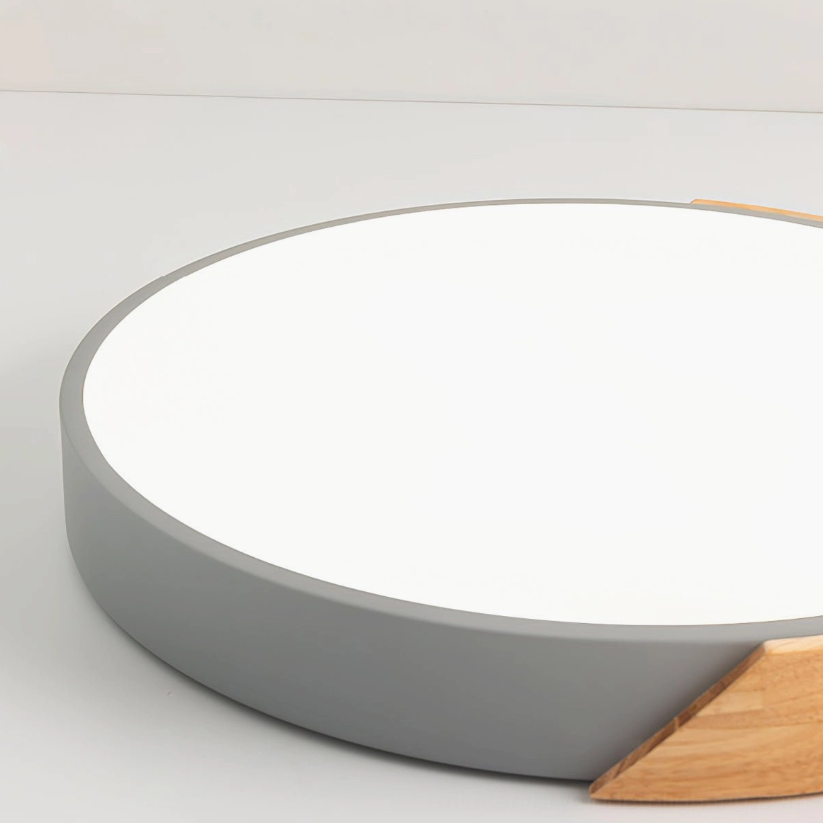 Large circular light diffuser of Delphi ceiling fixture with matte gray frame and wood accent trim