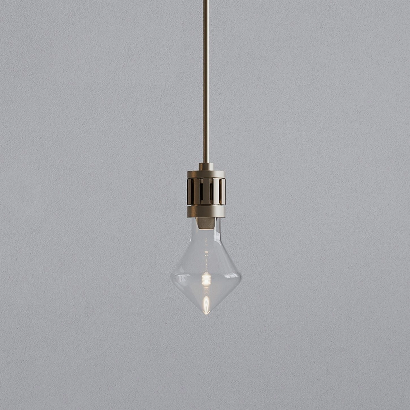 Detailed close-up of modern diamond glass pendant showing transparent rhombus shade and metal hardware against gray backdrop