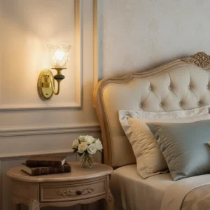 Brass wall sconce with ceramic detail in luxury master bedroom with warm ambient lighting