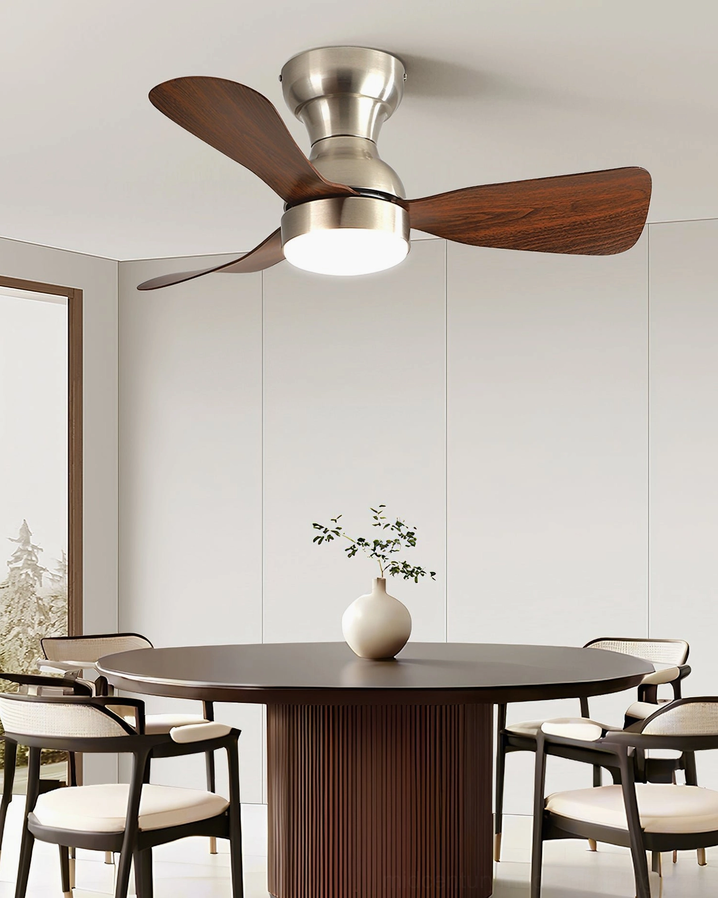 Modern dining room with round wooden table beneath ceiling fan light featuring dark wood grain blades and integrated LED illumination