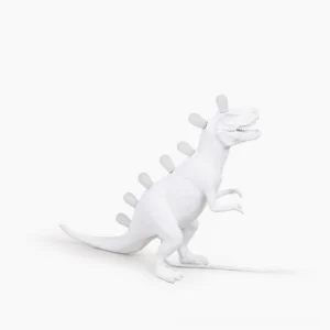 Dinosaur table lamp with glowing LED spine, rear three-quarter view showcasing matte white resin construction