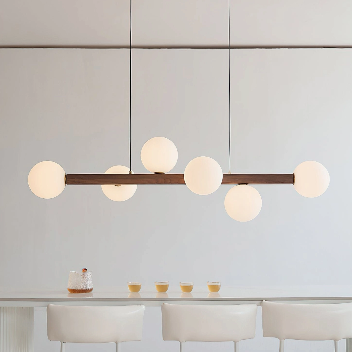 Dioniso walnut wood chandelier with glass globes illuminated in modern dining room setting