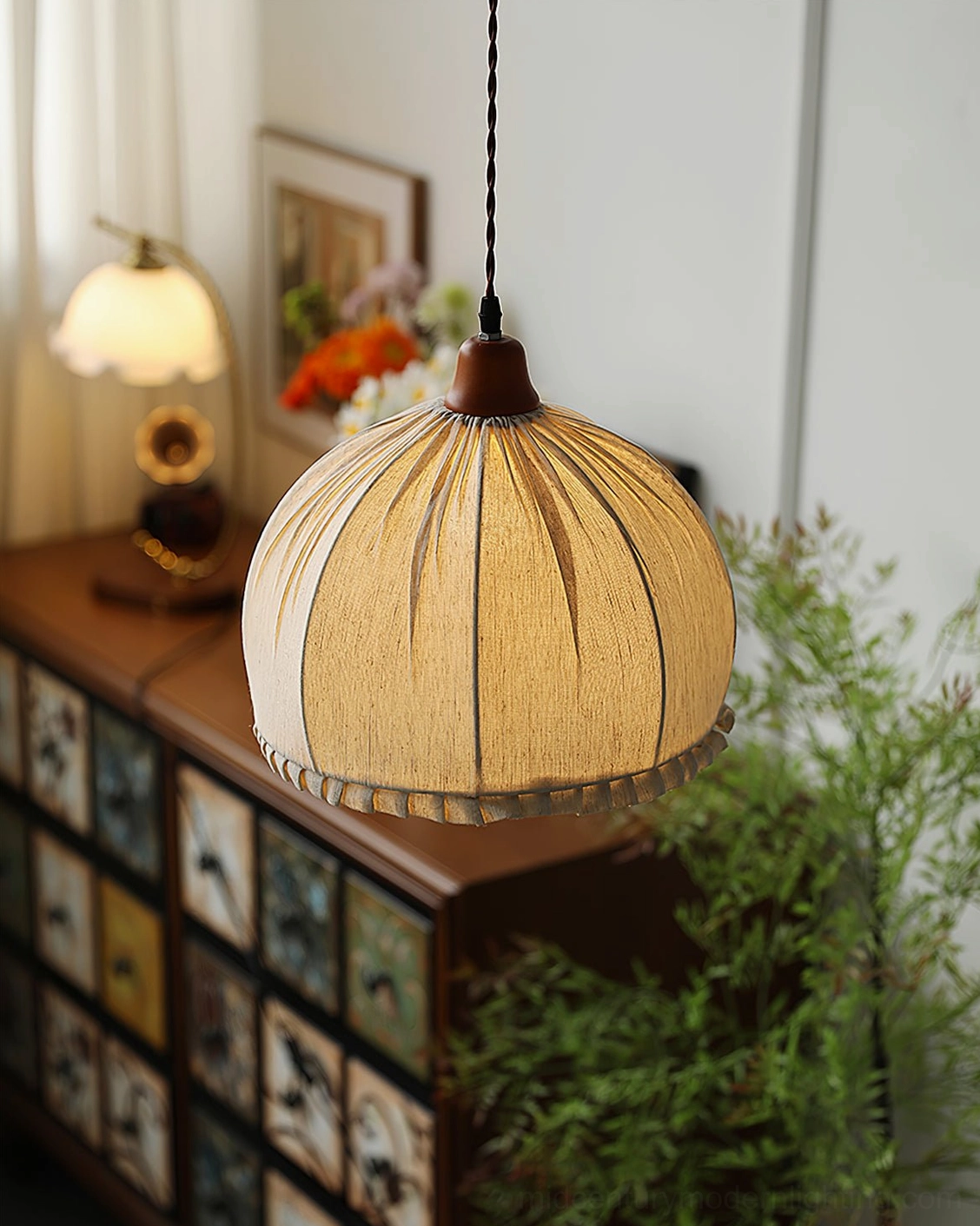 Dippa fabric pendant lamp front view in living room with storage cabinet and botanical decor
