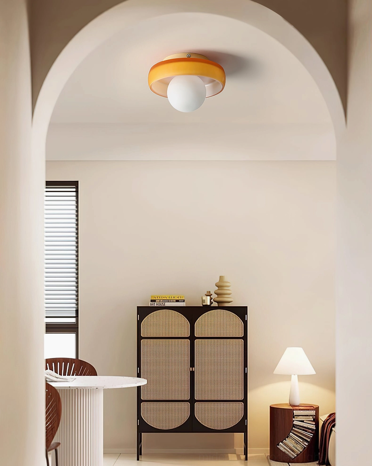 Orange Disc Orb Ceiling Light illuminating minimalist dining area with storage cabinet and table lamp