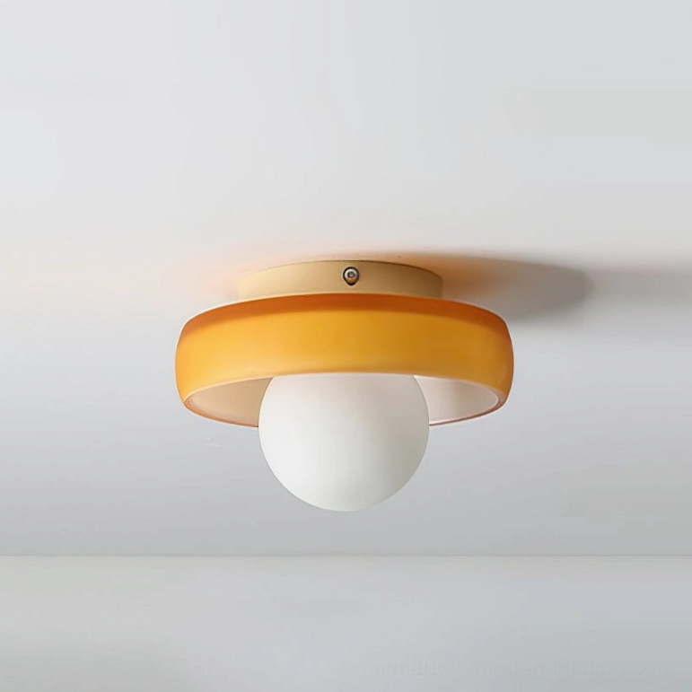 Mid-century modern orange disc ceiling light fixture mounted flush to ceiling, flat overhead view