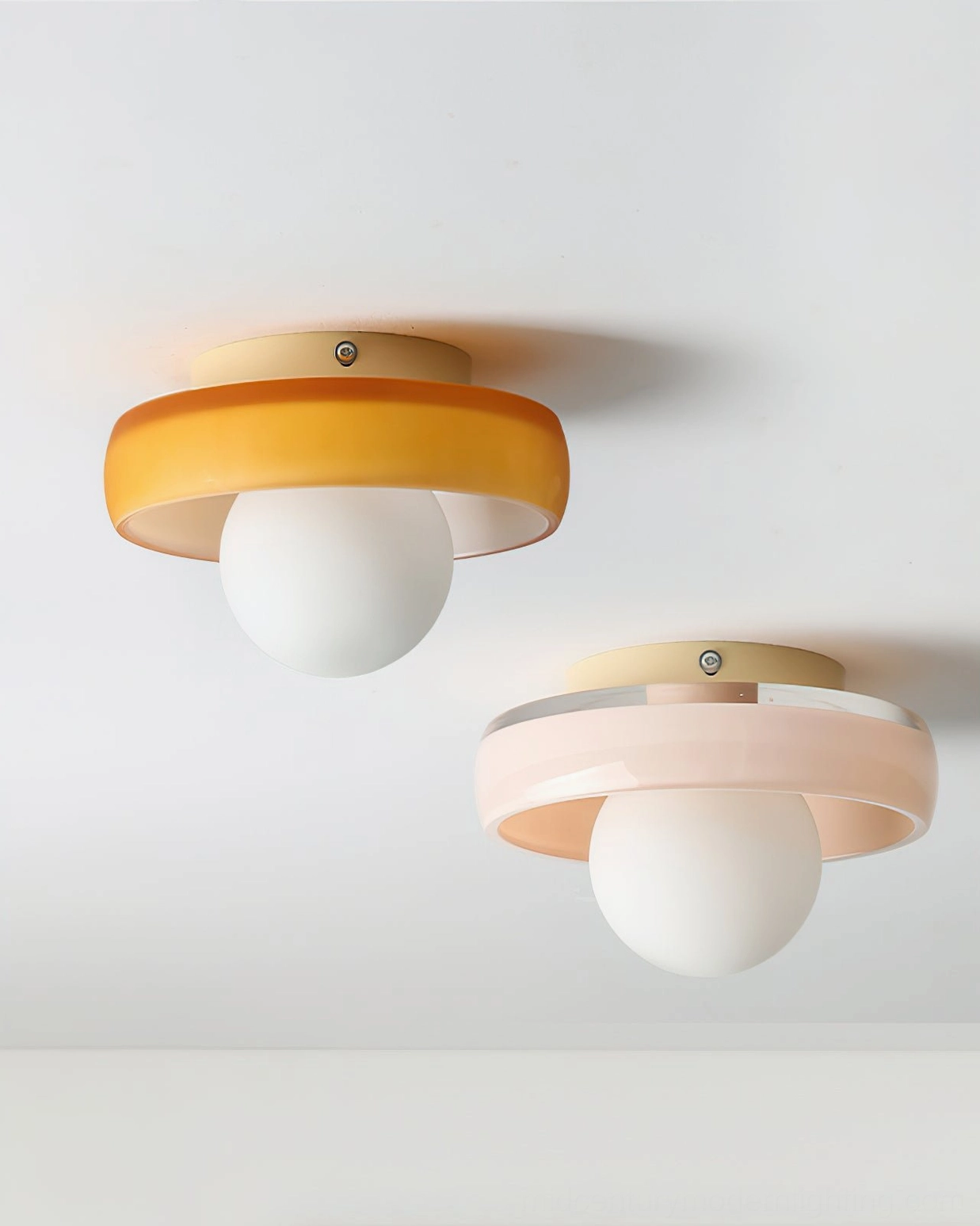 Two disc orb ceiling lights, one orange and one pink, paired together showcasing color variants