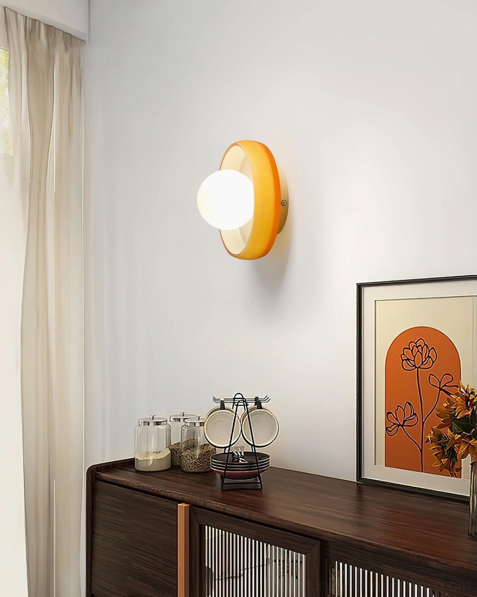 Orange frosted disc orb sconce as wall-mounted accent light in modern home corner with sideboard