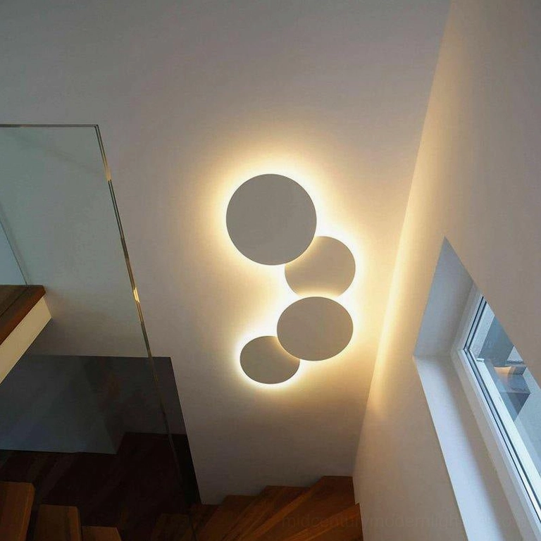 Modern disc wall installation with overlapping circles creating visual depth and spatial complexity in minimalist aesthetics