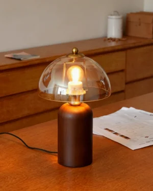 Disko table lamp styled on wooden desk, warm amber light illuminating workspace with warm tone