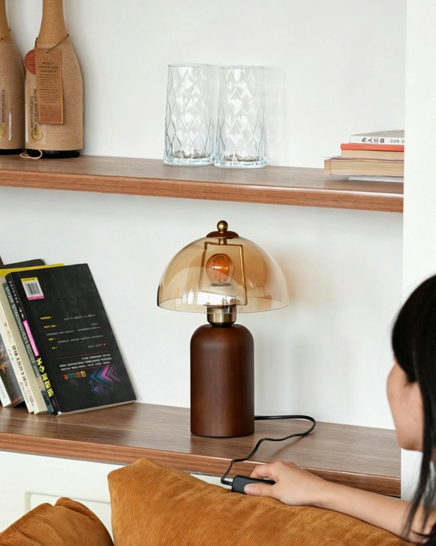 Disko table lamp on living room shelf beside reading materials, warm amber light in interior setting