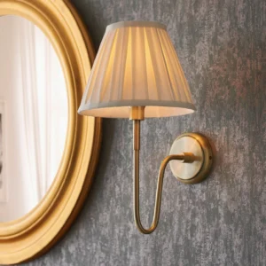 Dixon wall sconce curved brass arm close-up detail with textured wall background