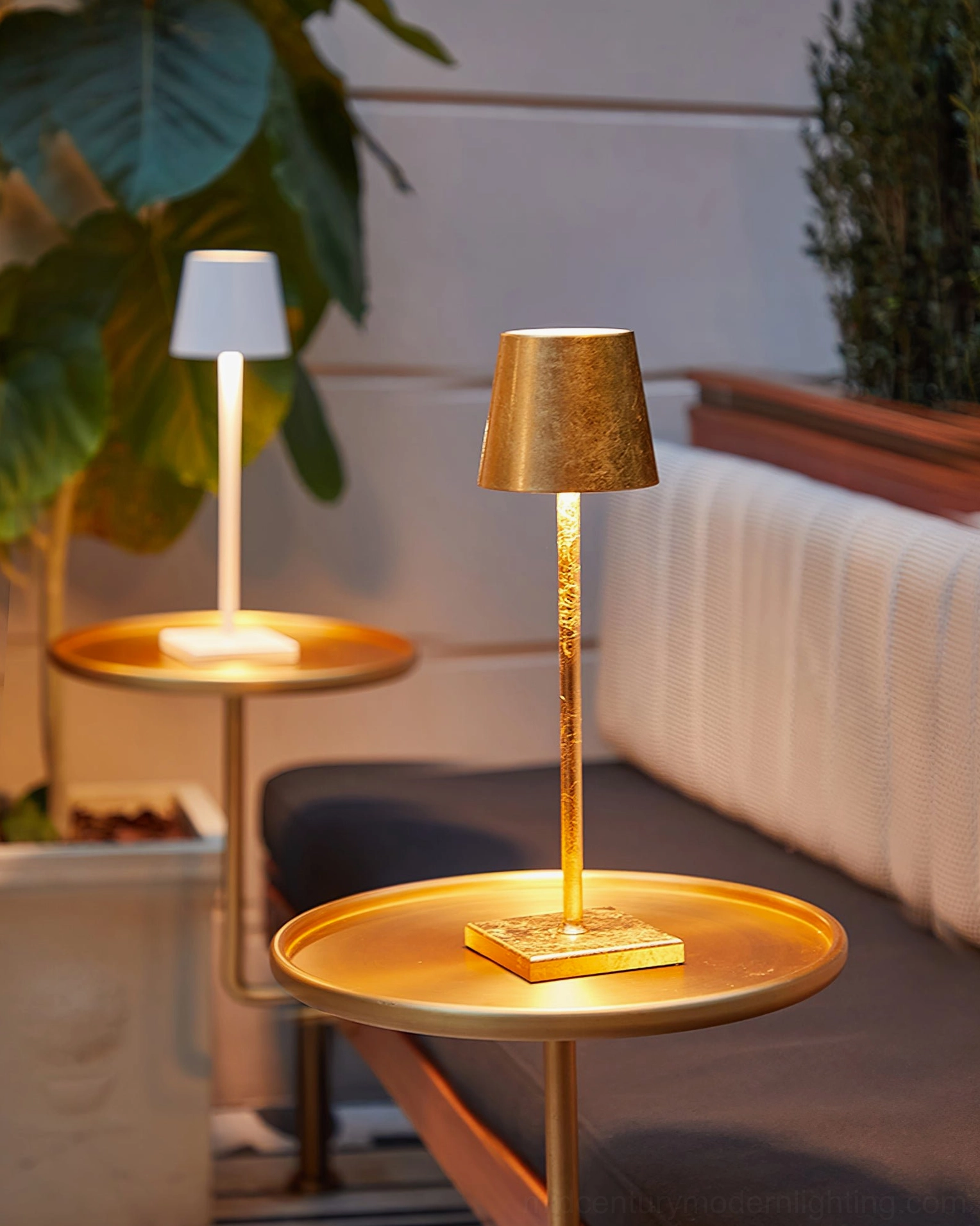 Two Doku rechargeable table lamps in warm finishes on living room side tables with plant accents