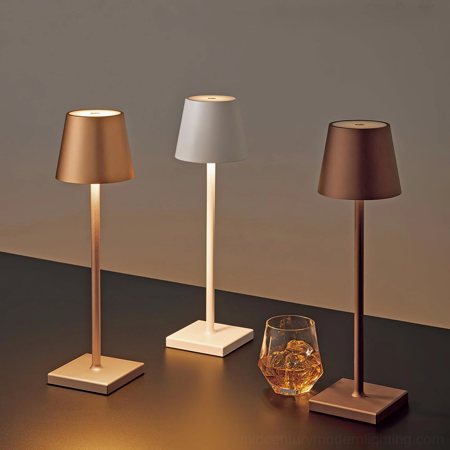 Doku cordless lamps in copper, white and dark brown finishes on product display table, overhead view